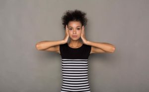 African-american woman puts her hands on head. Portrait of young serious girl closing her ears, hear nothing, deafness concept